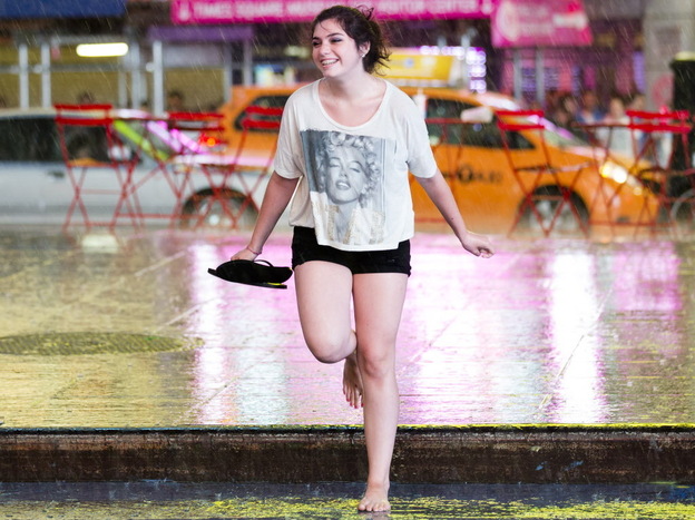 Dancing in the rain: New York City got some relief from the heat as early as Saturday, when this young woman danced in the rain in Times Square.