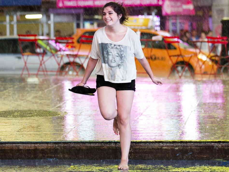 Dancing in the rain: New York City got some relief from the heat as early as Saturday, when this young woman danced in the rain in Times Square.