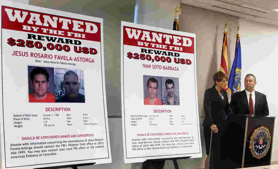 With wanted posters off to the side, James L. Turgal, Jr., right, FBI Special Agent in Charge, listens as Laura E. Duffy, United States Attorney Southern District of California, announces the indictments on five suspects involved in the death of U.S. Border Patrol agent Brian Terry on Monday.
