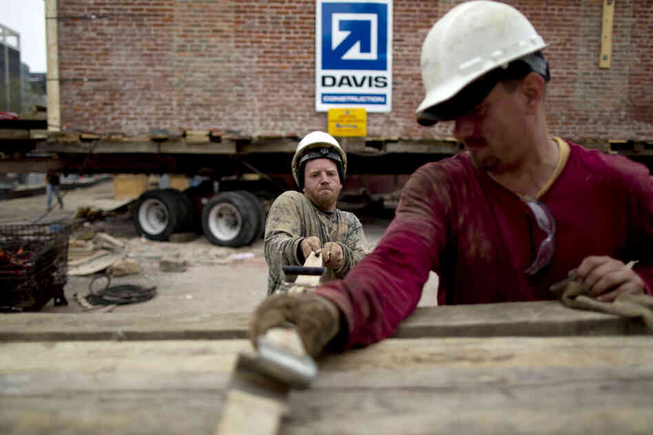 Workers tighten straps in preparation for the move.