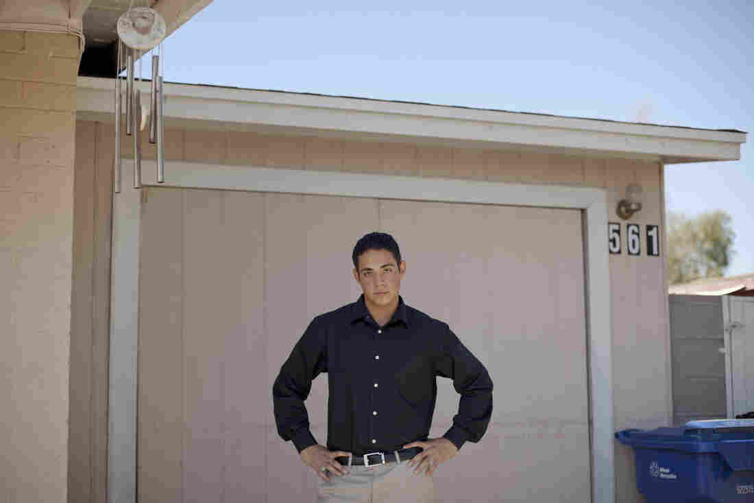Luis De La Cruz stands in front of the garage where he lived without air conditioning near Phoenix. He lived there with his brother while finishing high school after his father was deported and his mother abandoned them. He is now an honors student at Arizona State University.