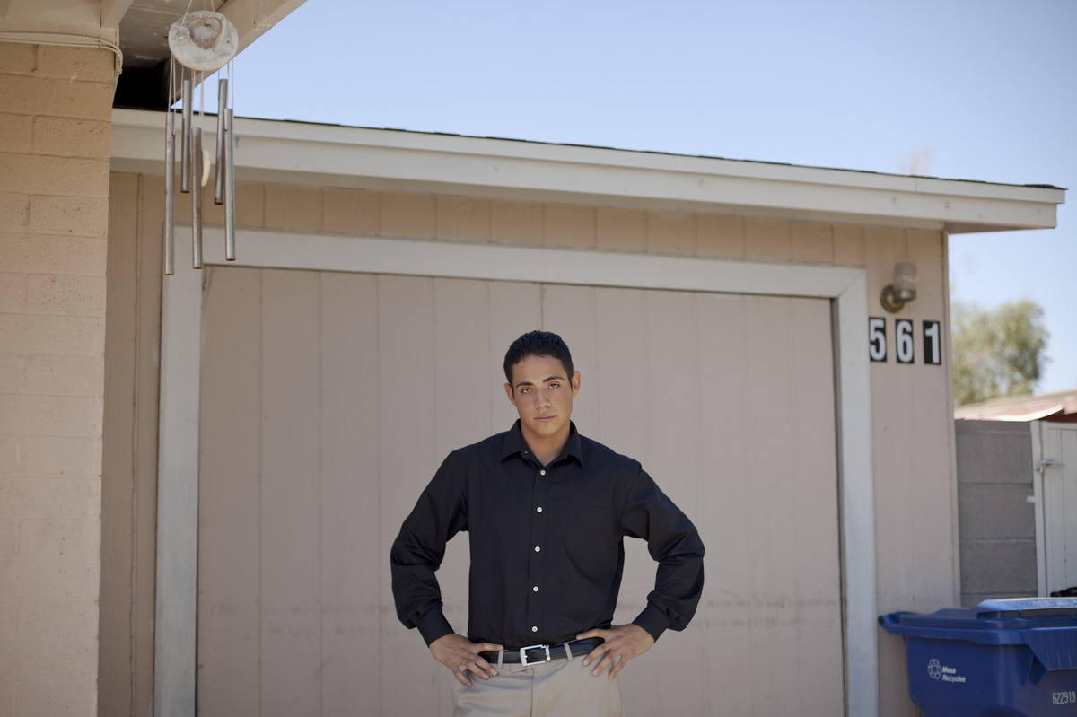Luis De La Cruz stands in front of the garage where he lived without air conditioning near Phoenix. He lived there with his brother while finishing high school after his father was deported and his mother abandoned them. He is now an honors student at Arizona State University.