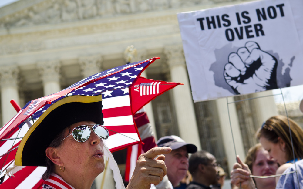 Susan Clark (left) argues with another protester about the Affordable Care Act outside the U.S. Supreme Court. Chief Justice John Roberts likened the law's Medicaid expansion provision to "a gun to the head" of states.