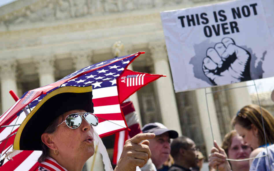 Susan Clark (left) argues with another protester about the Affordable Care Act outside the U.S. Supreme Court. Chief Justice John Roberts likened the law's Medicaid expansion provision to "a gun to the head" of states.