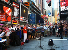 Conductor Kent Tritle leads an impromptu choir in the world premiere of Philip Glass' "A New Rule" in New York's Times Square.