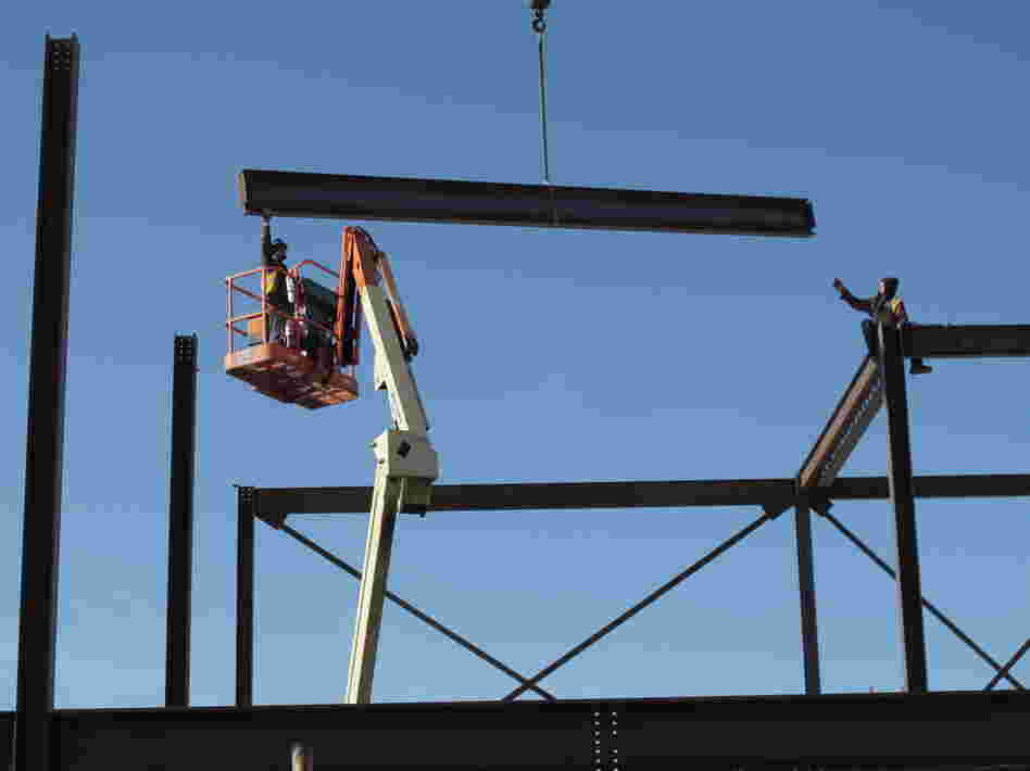 Construction workers ease a steel girder into place as part of a remodeling and expansion of the North Dakota State Penitentiary in Bismarck, N.D. An energy boom has helped the state maintain a budget surplus.