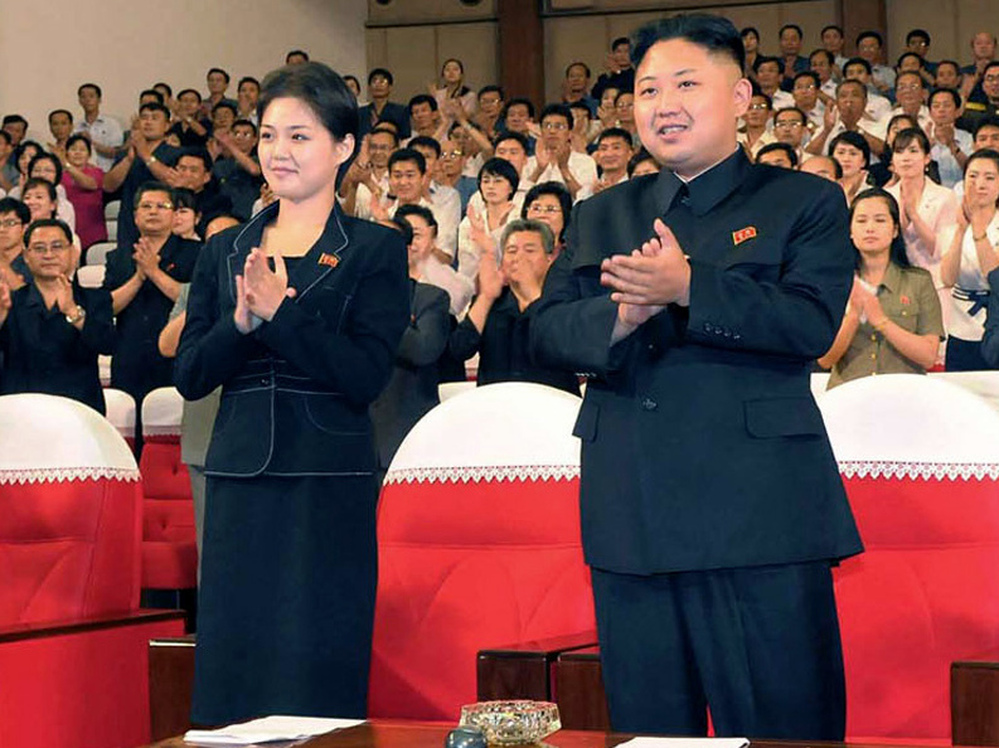 In this photo released by the Korean Central News Agency (KCNA) and distributed in Tokyo by the Korea News Service on Monday, July 9, 2012, North Korean leader Kim Jong Un, right, and a woman clap with others on Friday as they watch a performance by North Korea's new Moranbong band in Pyongyang. Observers think she is Hyon Song-wol.