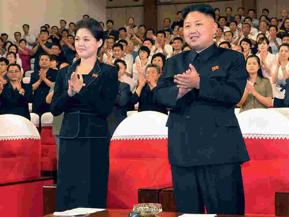 In this photo released by the Korean Central News Agency (KCNA) and distributed in Tokyo by the Korea News Service on Monday, July 9, 2012, North Korean leader Kim Jong Un, right, and a woman clap with others on Friday as they watch a performance by North Korea's new Moranbong band in Pyongyang. Observers think she is Hyon Song-wol.