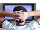 A young adult watching TV.