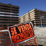 A "For Sale" sign hangs outside mostly empty apartment blocks in the Madrid satellite town of Sesena in February. Banks are trying to sell billions of euros worth of property left by bankrupt developers. This is attracting bargain-hunting investors from abroad.