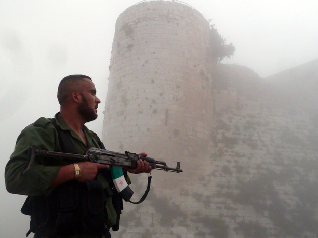 A member of the Free Syrian Army stands near a medieval castle outside Homs, a flashpoint for much of the recent fighting, last month. The Syrian army continues to wage offensives against the rebels in many places, but the rebels say they can move back and forth between northwest Syria and southern Turkey.
