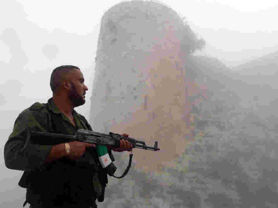 A member of the Free Syrian Army stands near a medieval castle outside Homs, a flashpoint for much of the recent fighting, last month. The Syrian army continues to wage offensives against the rebels in many places, but the rebels say they can move back and forth between northwest Syria and southern Turkey.