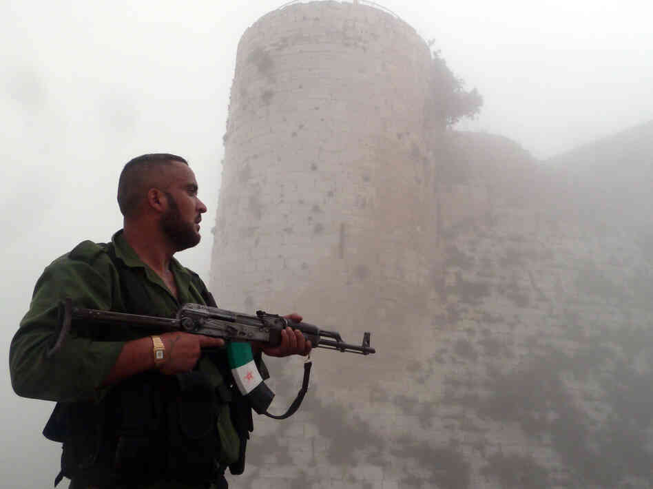 A member of the Free Syrian Army stands near a medieval castle outside Homs, a flashpoint for much of the recent fighting, last month. The Syrian army continues to wage offensives against the rebels in many places, but the rebels say they can move back and forth between northwest Syria and southern Turkey.