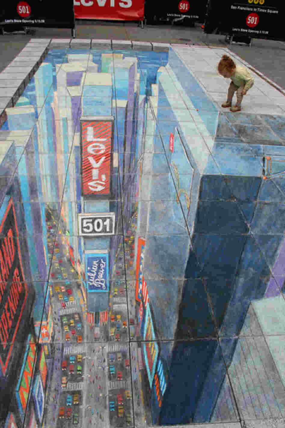 A toddler peers over the edge of a chalk drawing of a building.