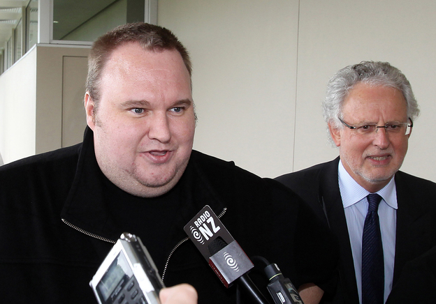 Megaupload boss Kim Dotcom, left, leaves court after he was granted bail in the in Auckland, New Zealand.