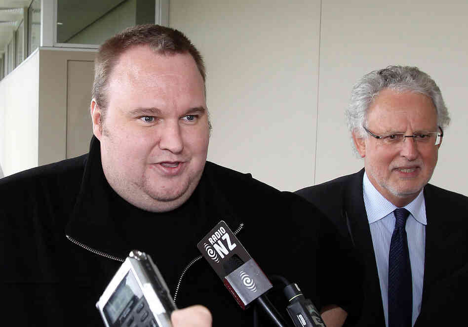 Megaupload boss Kim Dotcom, left, leaves court after he was granted bail in the in Auckland, New Zealand.
