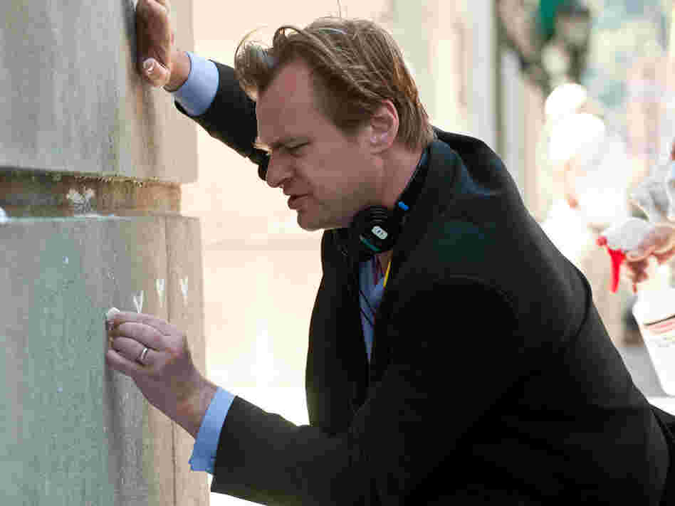 Christopher Nolan on the set of The Dark Knight Rises, drawing some Batman graffiti.