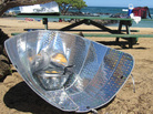 Corn dogs sizzle in a solar cooker made from reflective car windshield shades. Corn dogs sizzle in a solar cooker made from reflective car windshield shades.