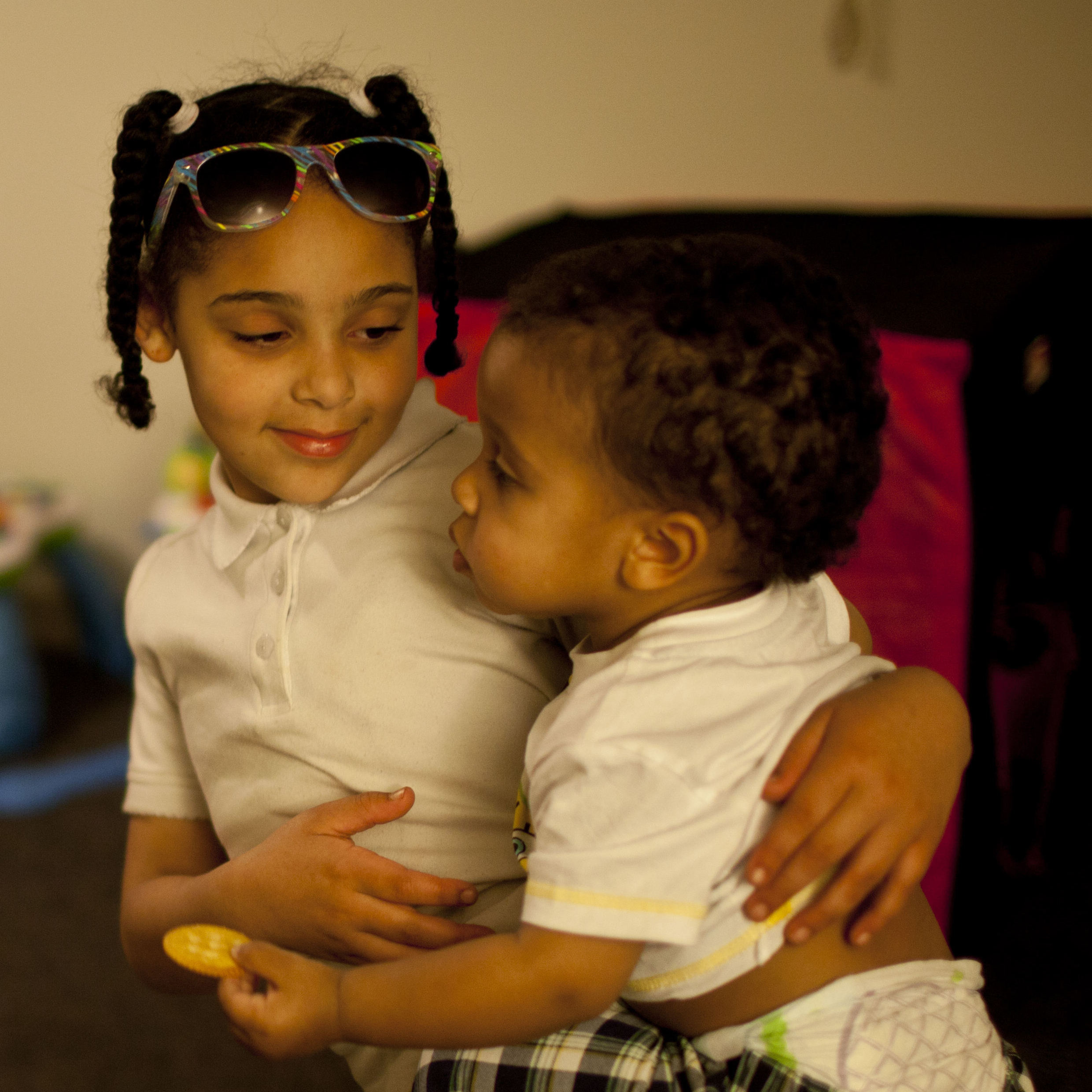 Shyanne (left) holds 1-year-old Makai, as Stepp checks to see if all of Shyanne's homework has been completed.