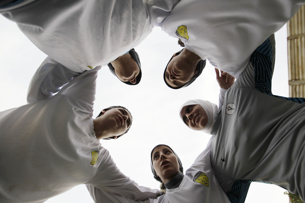 In this May photo, members of a Saudi female soccer team listen to their captain, Rawh Abdullah, before their training session at a secret location in Riyadh. The decision to send female athletes to the Olympics will definitely have consequences at home.