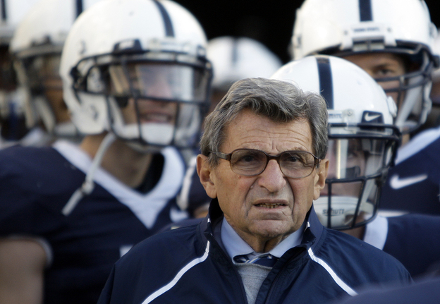Former Penn State Coach Joe Paterno stands with his players in 2009.