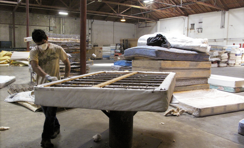 A worker dismantles a mattress at a recycling facility in Oakland, Calif. The material will be used to make carpet products and proceeds will help support the St. Vincent de Paul Society of Lane County, a nonprofit that helps low-income families in Eugene, Ore.