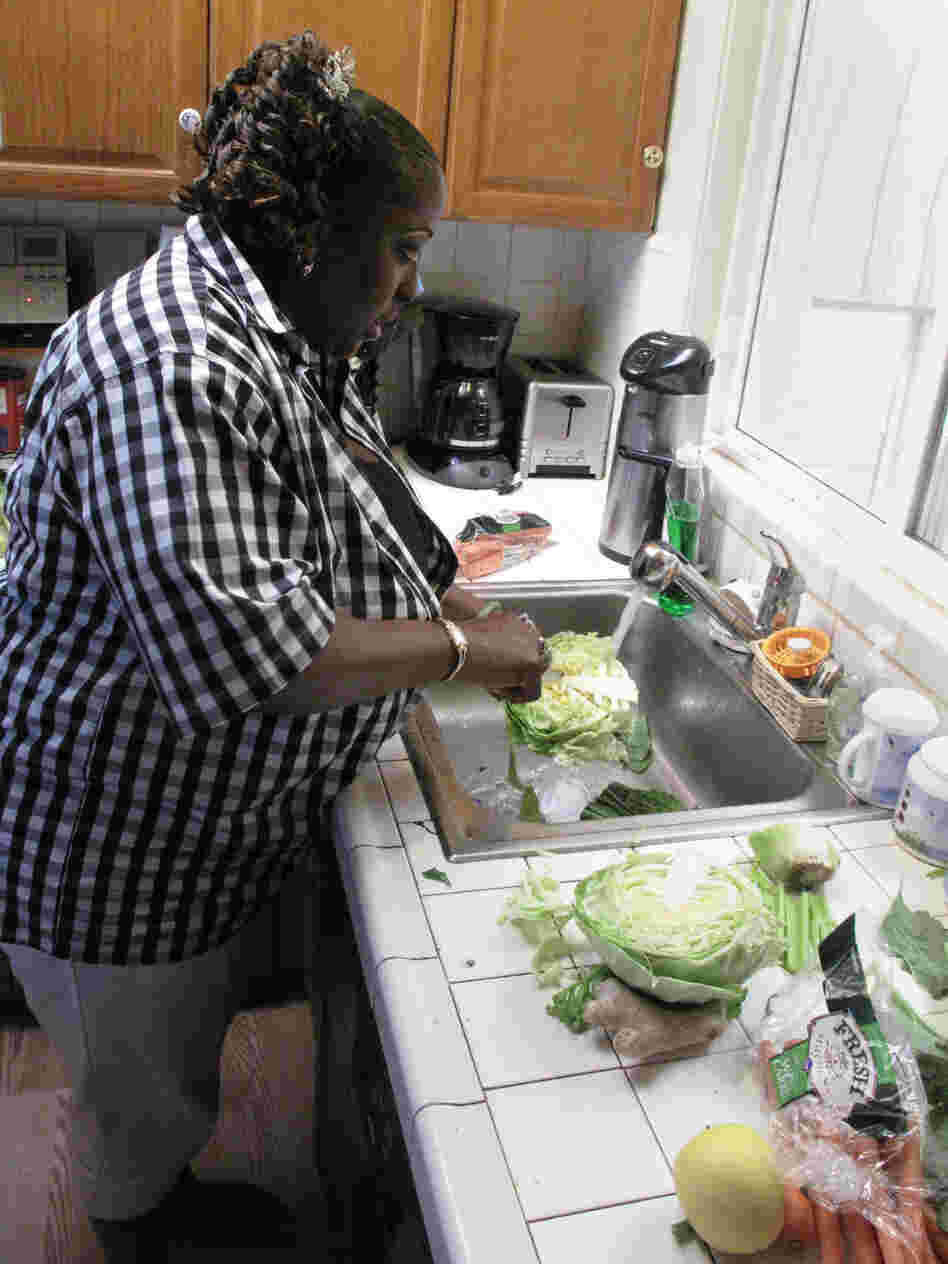 Yovanda Dixon washes vegetables in her San Francisco home to prepare a demonstration for her support group.