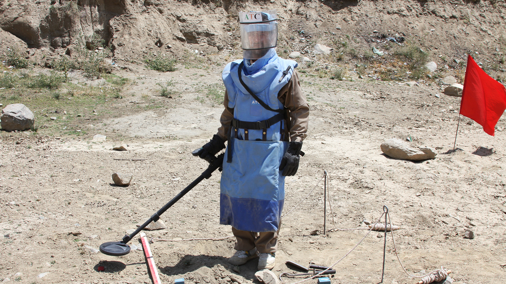 A de-mining expert demonstrates how to find land mines in a training area near Hakim Village in central Afghanistan, where Soviet mines dating to the 1980s are still a danger.