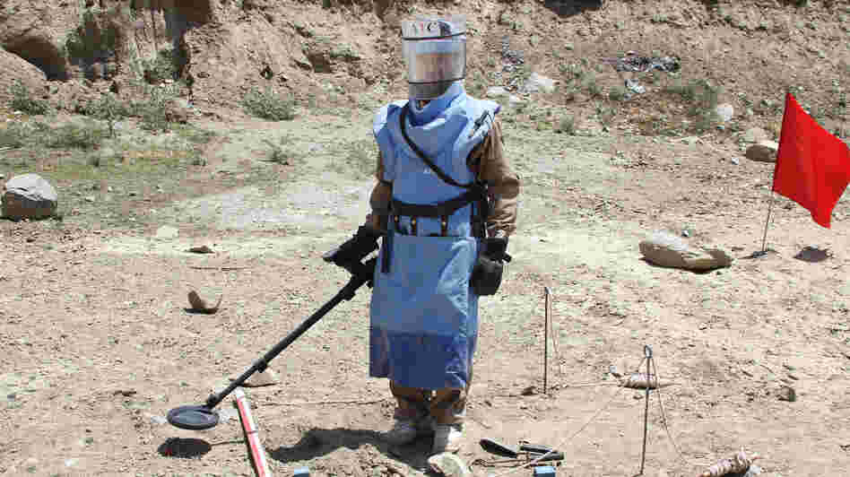 A de-mining expert demonstrates how to find land mines in a training area near Hakim Village in central Afghanistan, where Soviet mines dating to the 1980s are still a danger.