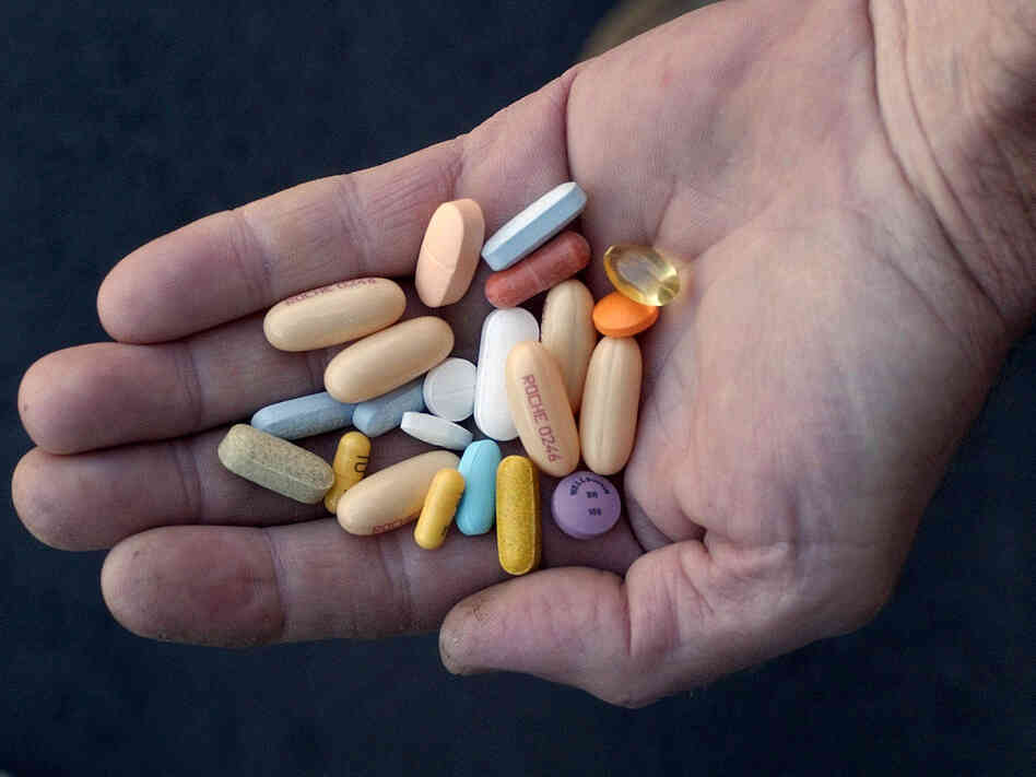 HIV treatment regimens, like the pills in this patient's hand, keep AIDS at bay, but can take a harsh physical toll over the course of many years.