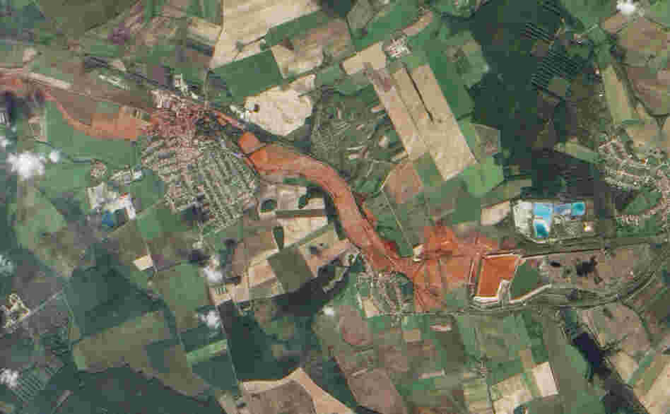 Aerial view of the toxic red sludge flowing from a breached waste reservoir (diamond shape at right) through the villages of Kolontar and Devecser.