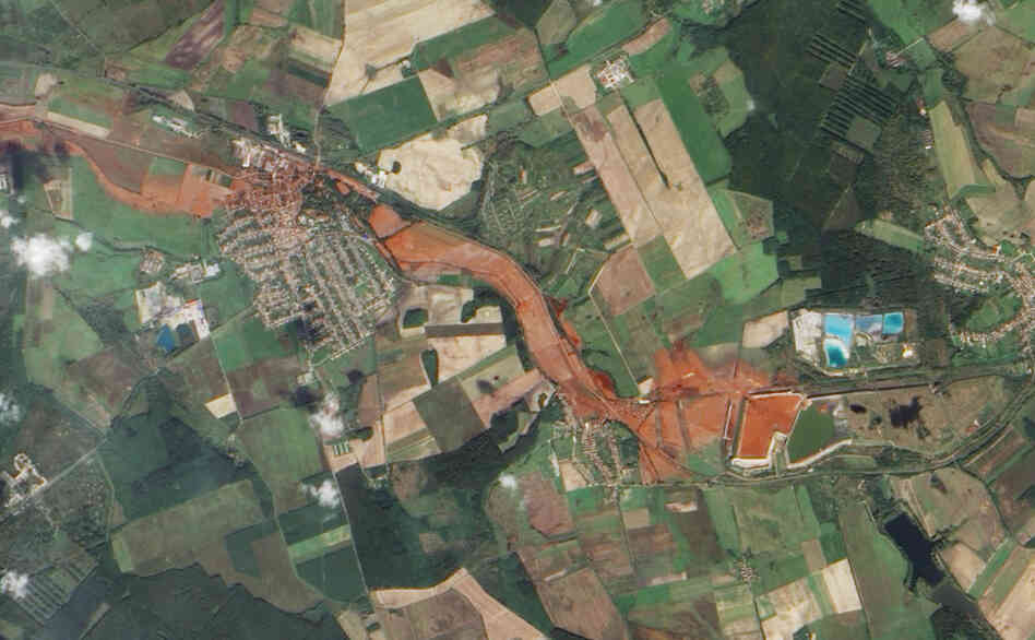 Aerial view of the toxic red sludge flowing from a breached waste reservoir (diamond shape at right) through the villages of Kolontar and Devecser.
