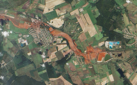 Aerial view of the toxic red sludge flowing from a breached waste reservoir (diamond shape at right) through the villages of Kolontar and Devecser. Aerial view of the toxic red sludge flowing from a breached waste reservoir (diamond shape at right) through the villages of Kolontar and Devecser.