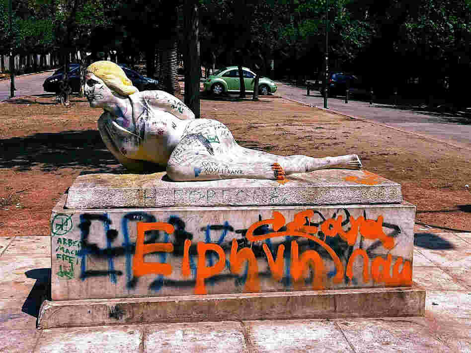 Graffiti coats a statue near the National Archaeological Museum in Athens. The street is often filled with drug users at night.