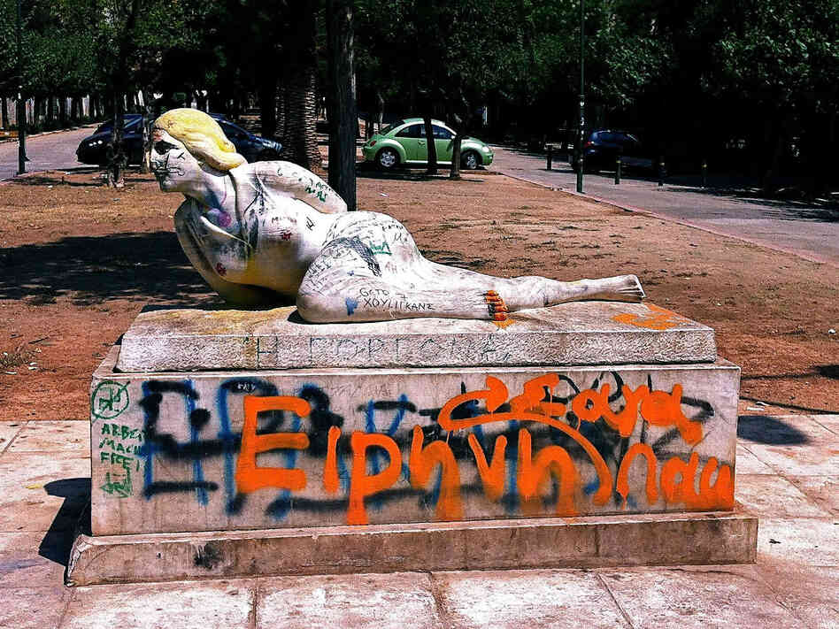 Graffiti coats a statue near the National Archaeological Museum in Athens. The street is often filled with drug users at night.