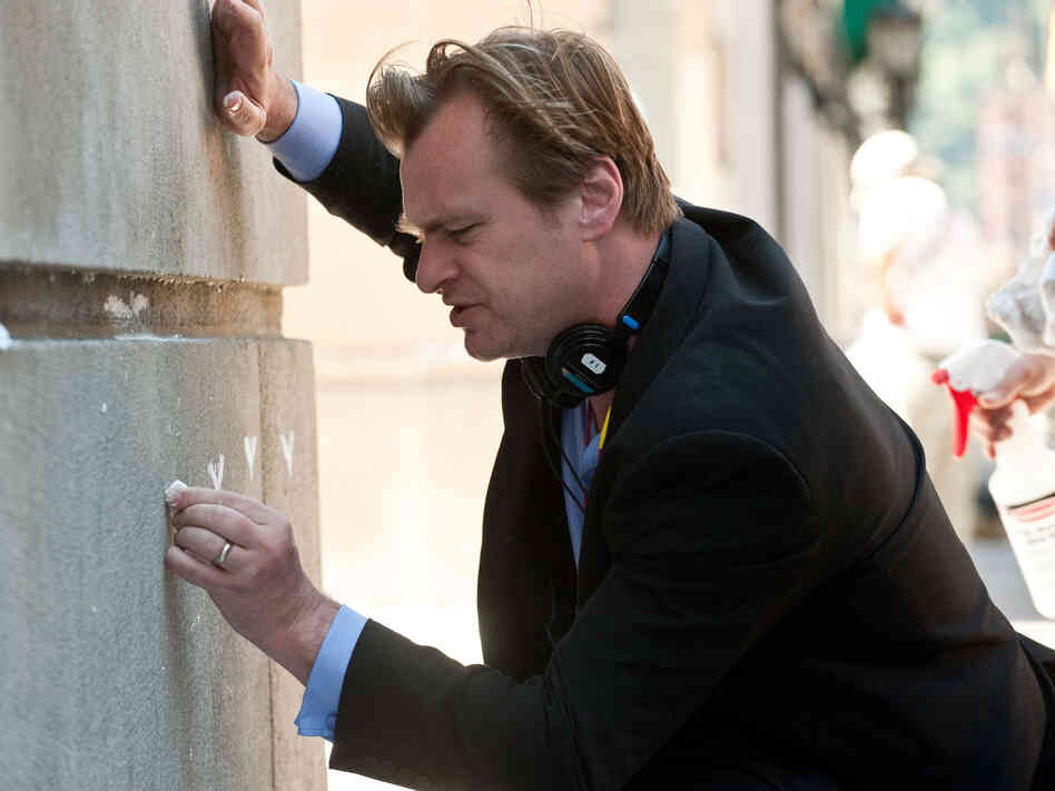 Christopher Nolan on the set of The Dark Knight Rises, drawing some Batman graffiti.