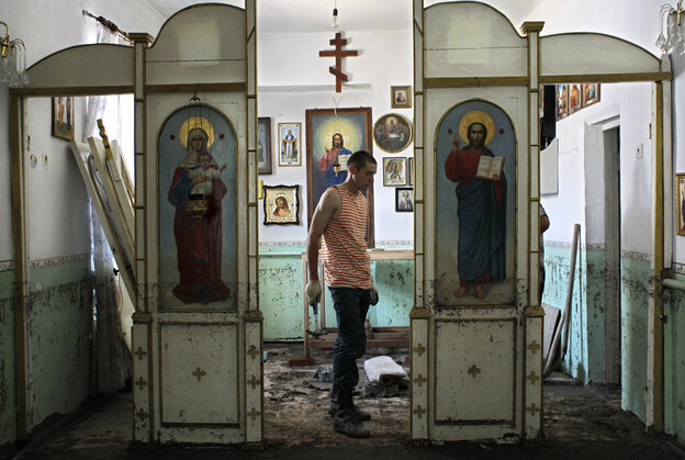 An Emergency Ministry soldier helps to repair religious icons in a church hit by flood water in the town of Nizhnebakansky, about 750 miles south of Moscow, on Tuesday.