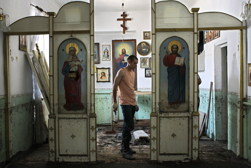 An Emergency Ministry soldier helps to repair religious icons in a church hit by flood water in the town of Nizhnebakansky, about 750 miles south of Moscow, on Tuesday.