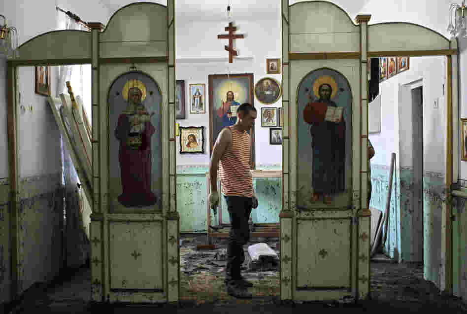 An Emergency Ministry soldier helps to repair religious icons in a church hit by flood water in the town of Nizhnebakansky, about 750 miles south of Moscow, on Tuesday.