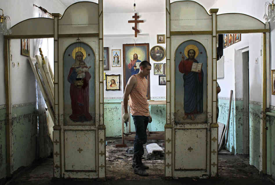 An Emergency Ministry soldier helps to repair religious icons in a church hit by flood water in the town of Nizhnebakansky, about 750 miles south of Moscow, on Tuesday.