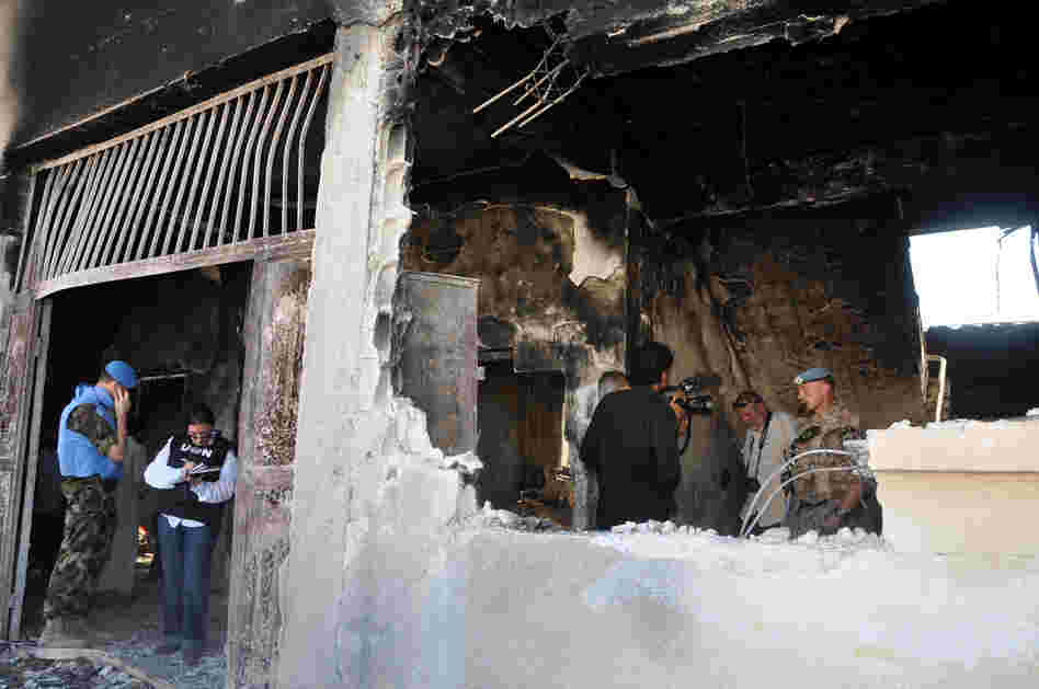 UN observers inspect a bombed-out school in the Syrian village of Tremsah, where as many as 200 people may have been killed after an armed conflict erupted last week.
