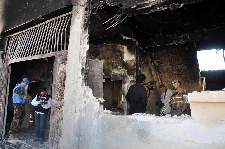 UN observers inspect a bombed-out school in the Syrian village of Tremsah, where as many as 200 people may have been killed after an armed conflict erupted last week.