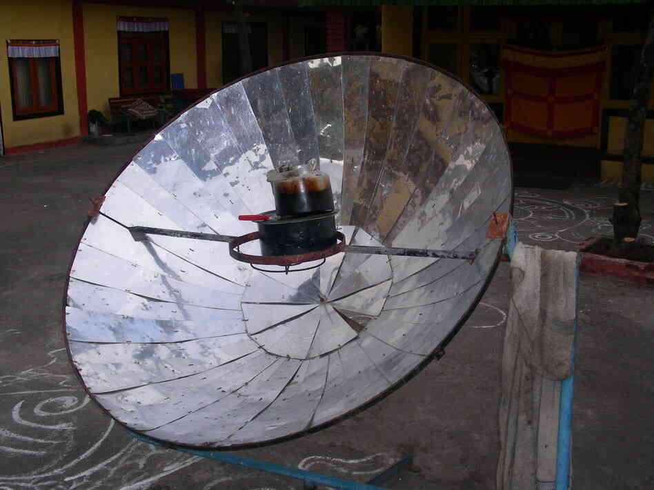 A parabolic solar cooker heats up a tea kettle in Nepal.