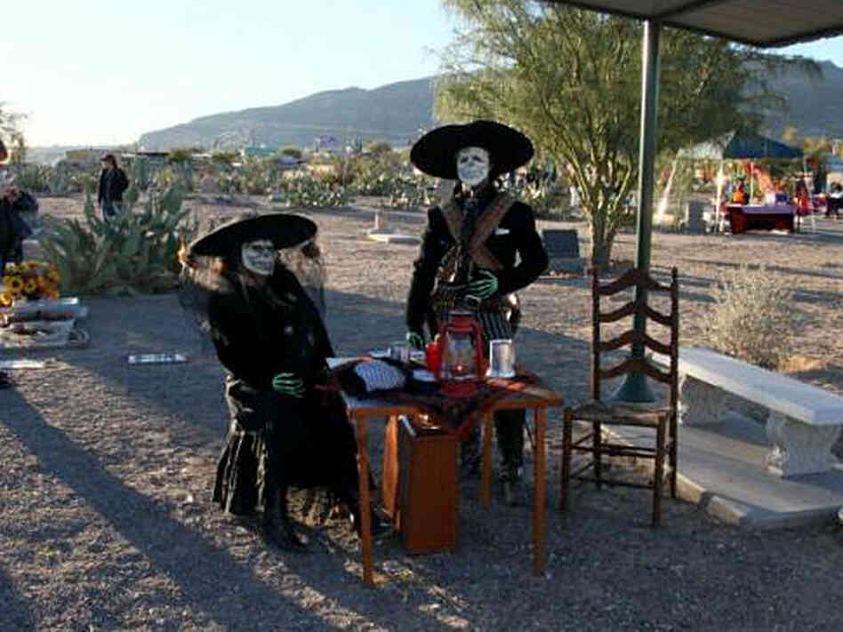 A couple celebrates Dia de los Muertos at the Concordia Cemetery.