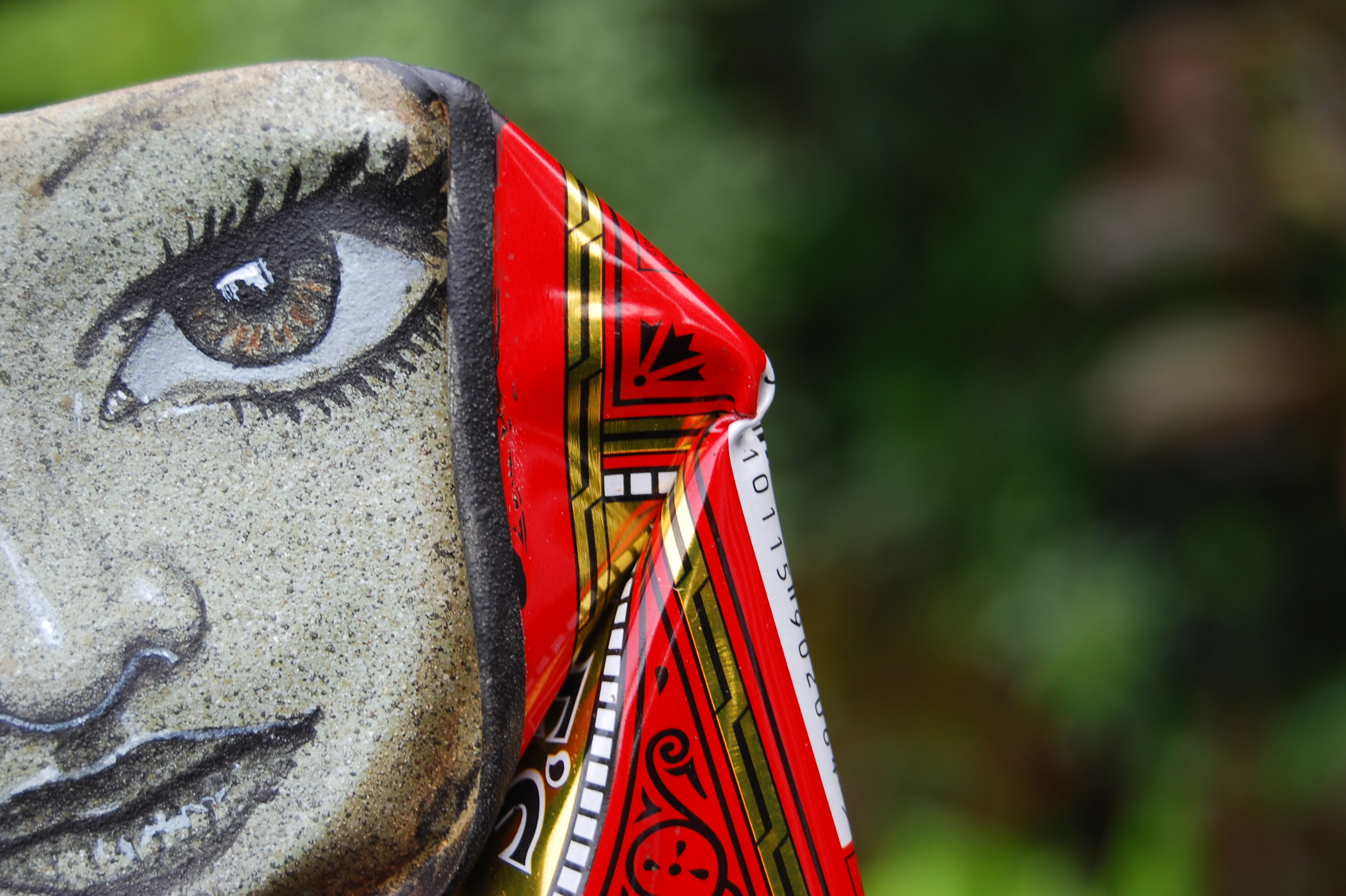 Half of a face, peeping out from a Lyle's Black Treacle can.