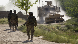 Afghan soldiers walk toward a U.S. Army mine-sweeping vehicle in southern Afghanistan on June 10. Roadside bombs remain a major threat to U.S. and Afghan troops, as well as civilians.