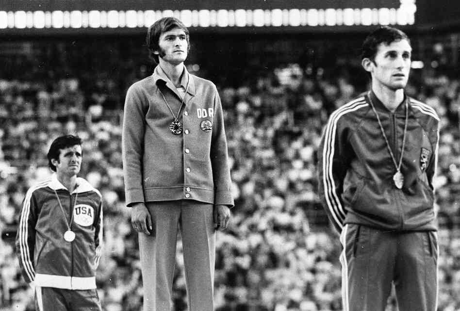 Marathon medal winners listen to the anthem from the victory stand during the presentation ceremony at the XXI Summer Olympic Games in Montreal in 1976. From left, Frank Shorter, U.S.A., silver; Waldemar Cierpinski, East Germany, gold, Olympic record; and Karel Lismont, Belgium, bronze. Evidence of doping by the East Germans suggests that Shorter deserved the gold medal.