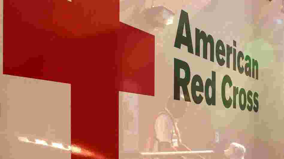 Red Cross volunteers are reflected in an emergency-response vehicle as they stock supplies in Colorado Springs, Colo., in early July, ahead of visiting neighborhoods affected by the Waldo Canyon wildfire.