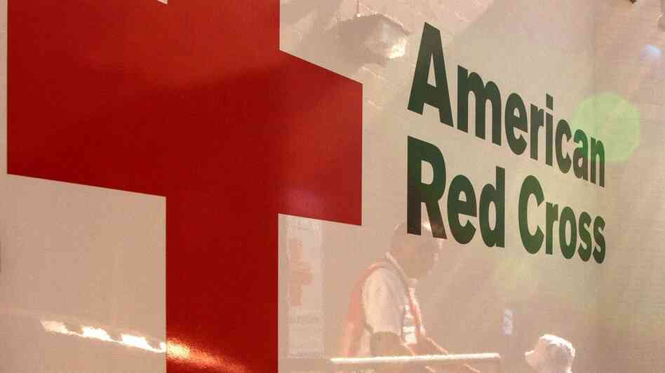 Red Cross volunteers are reflected in an emergency-response vehicle as they stock supplies in Colorado Springs, Colo., in early July, ahead of visiting neighborhoods affected by the Waldo Canyon wildfire.