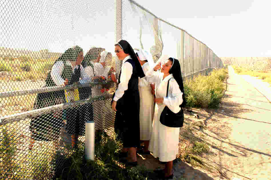 Sisters at the Border, 2007. Nuns meet at the border of Anapra, N.M. (left), and Barrio Anapra, Juarez. The nuns in Mexico cannot cross for various reasons — except on the day of a Mass for immigrants, held every November in the U.S.